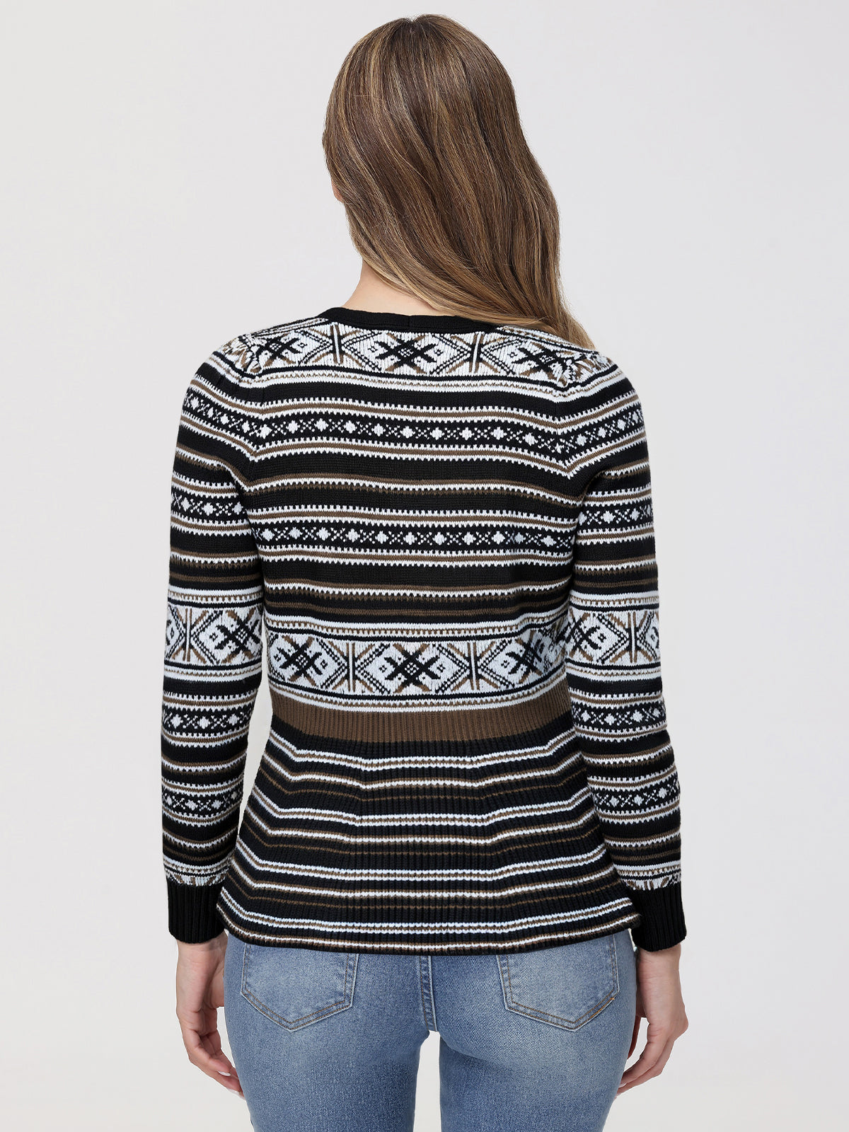 Person wearing a black patterned sweater on a plain background