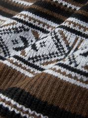 Close-up of a knitted fabric with a pattern featuring brown, black, and white colors.