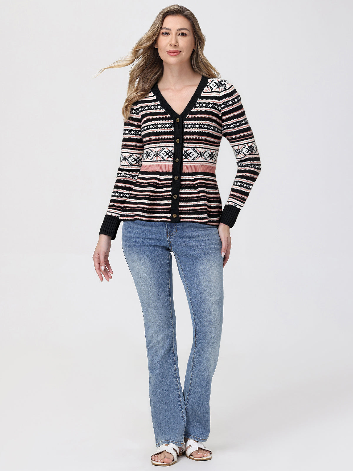 Woman wearing a patterned cardigan and jeans on a white background