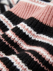 Close-up of a knitted fabric with black, pink, and white stripes.