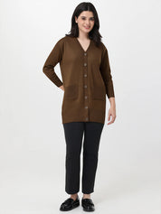 Woman wearing a brown cardigan over a black top and pants on a white background