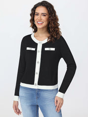 Woman wearing a black and white cardigan with blue jeans on a white background