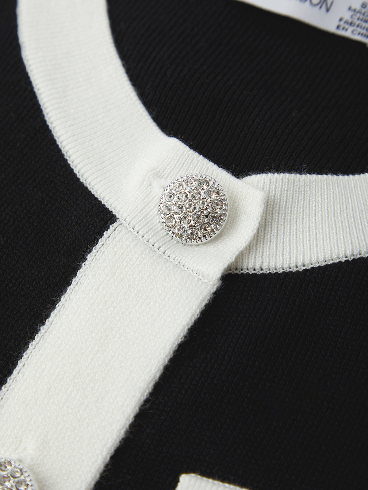 Close-up of a black and white striped garment with a decorative button.