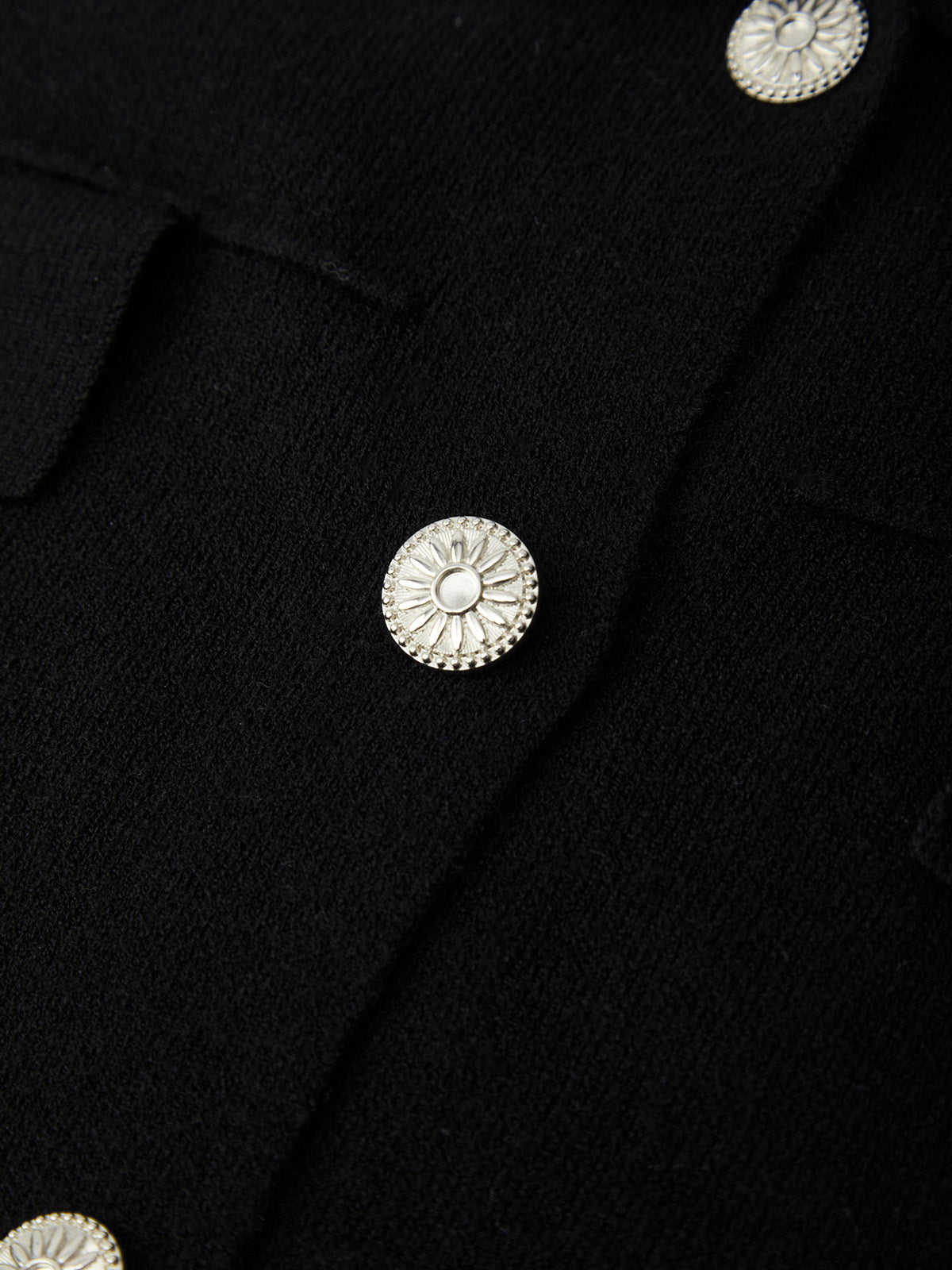 Close-up of a black cardigan with silver buttons