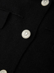Close-up of a black cardigan with silver buttons
