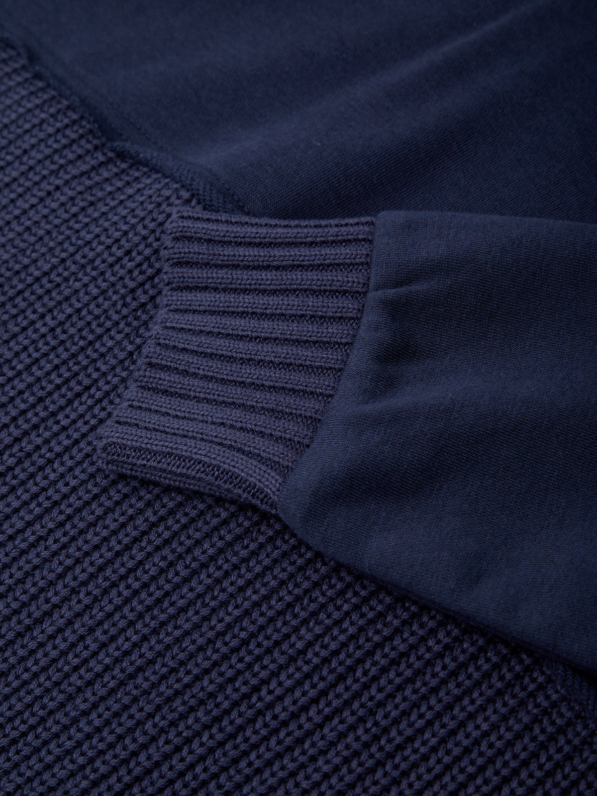 Close-up of a navy blue textured fabric with a ribbed edge.