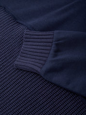 Close-up of a navy blue textured fabric with a ribbed edge.