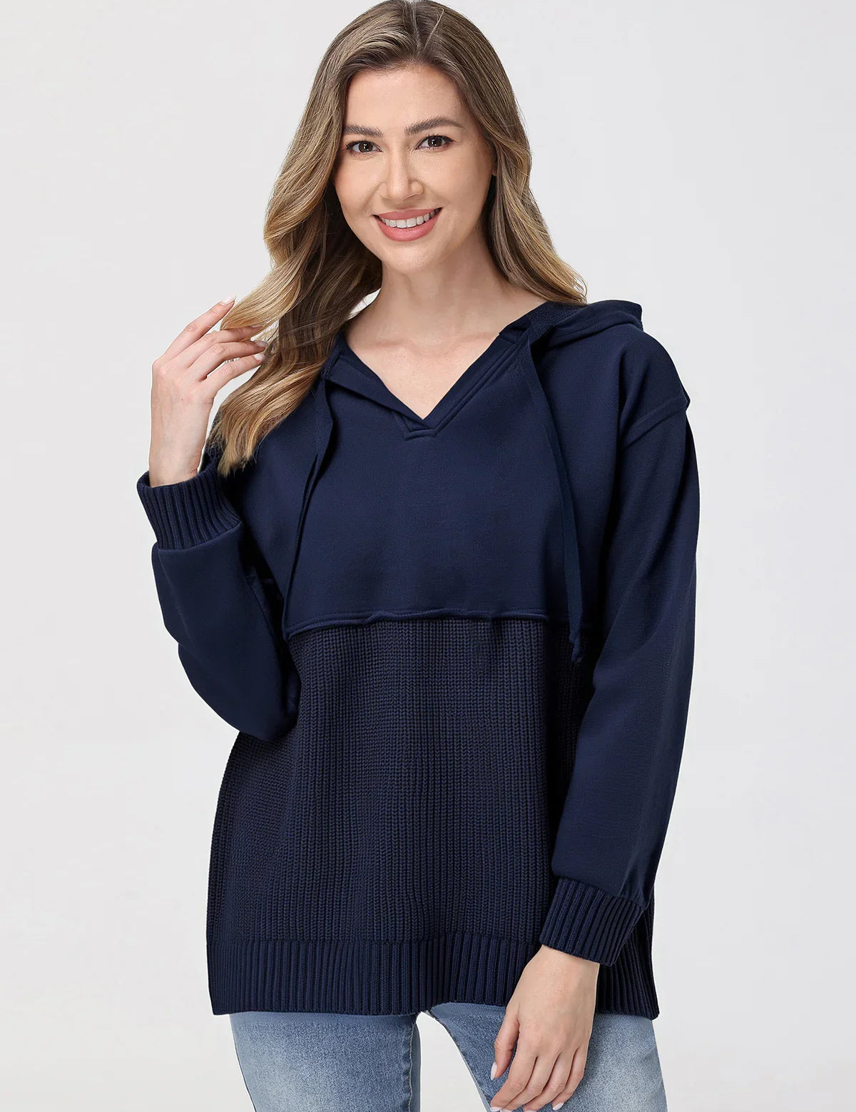 Woman wearing a navy blue hoodie with a white background