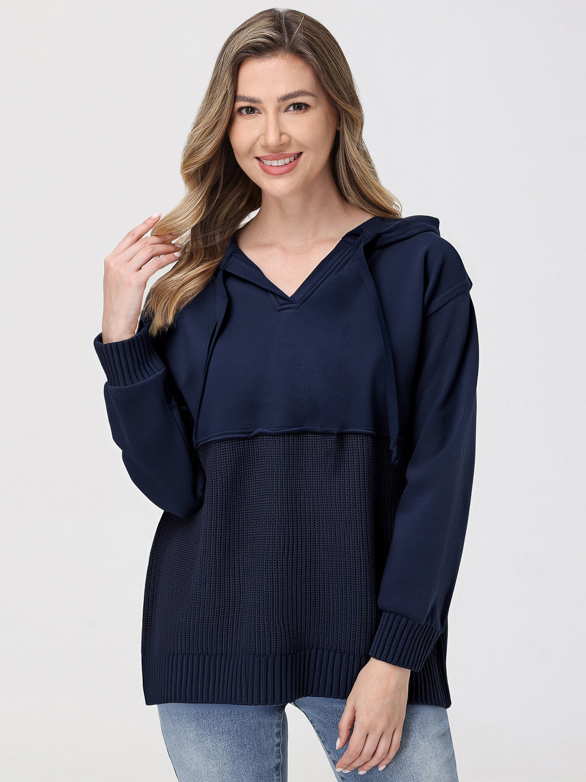 Woman wearing a navy blue hoodie with a white background