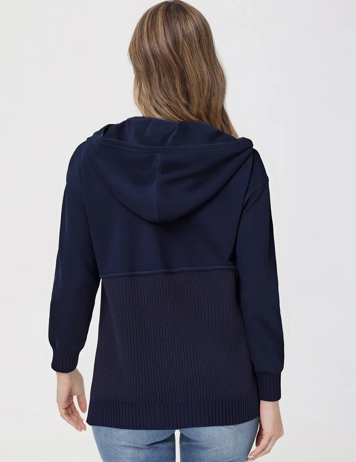 Person wearing a navy blue hoodie on a plain background