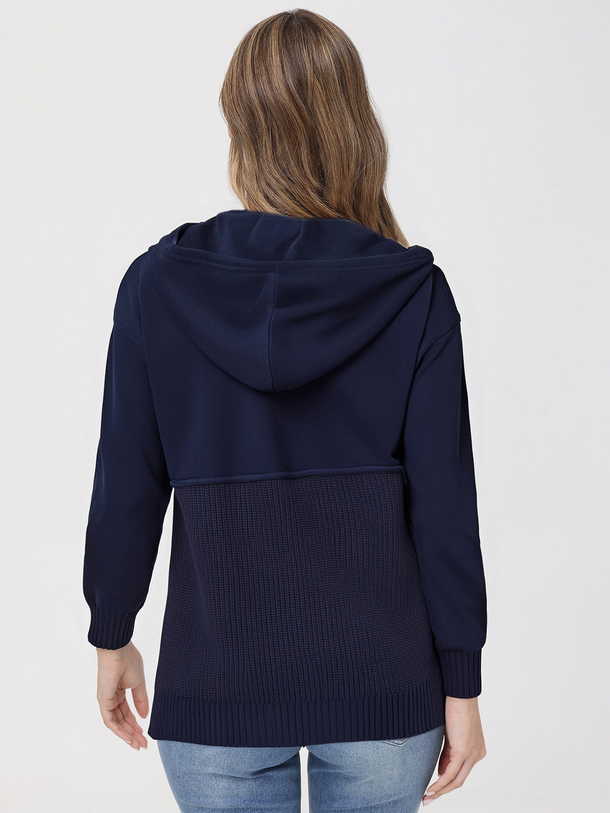 Person wearing a navy blue hoodie on a plain background