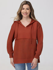 Woman wearing a rust-colored hoodie against a plain background