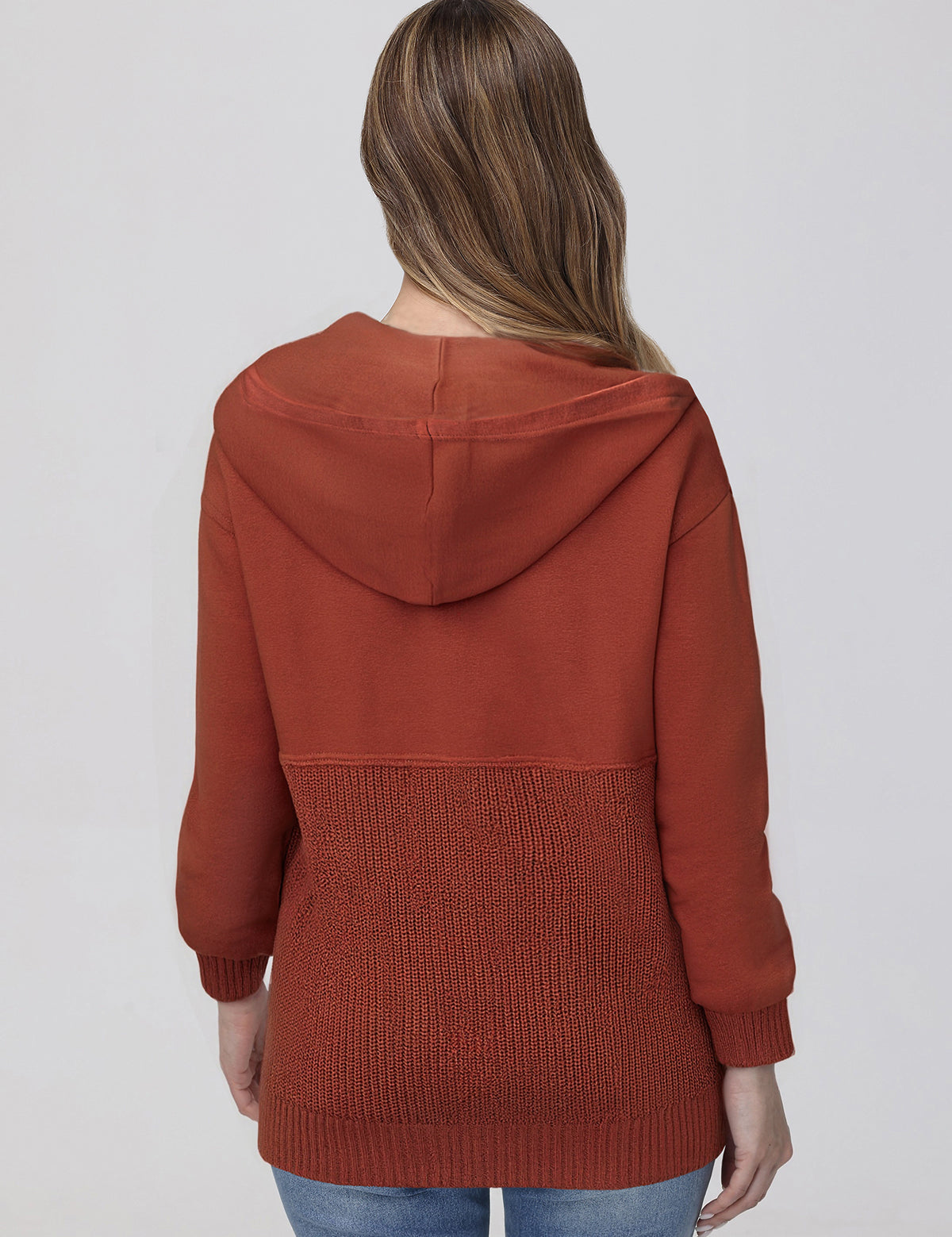 Person wearing a rust-colored hoodie on a plain background