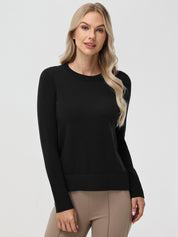 Woman wearing a black sweater and beige pants on a white background
