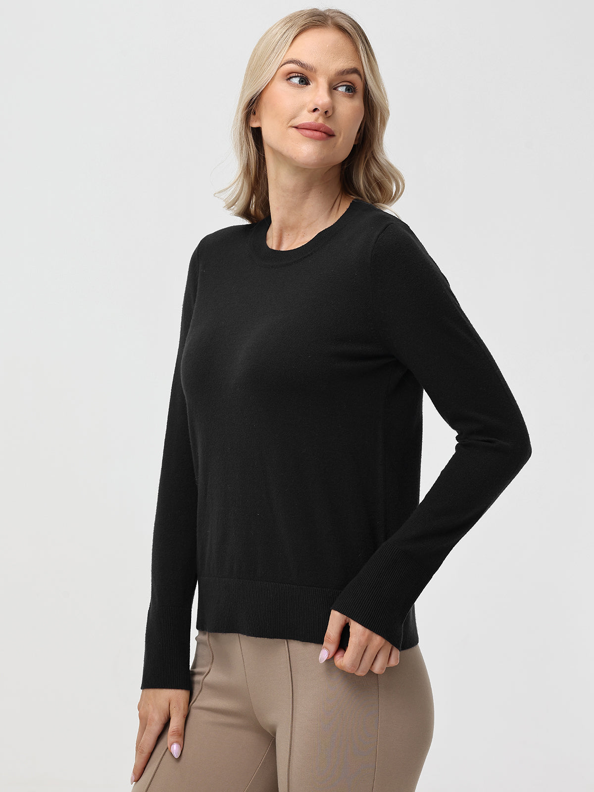 Woman wearing a black sweater against a white background