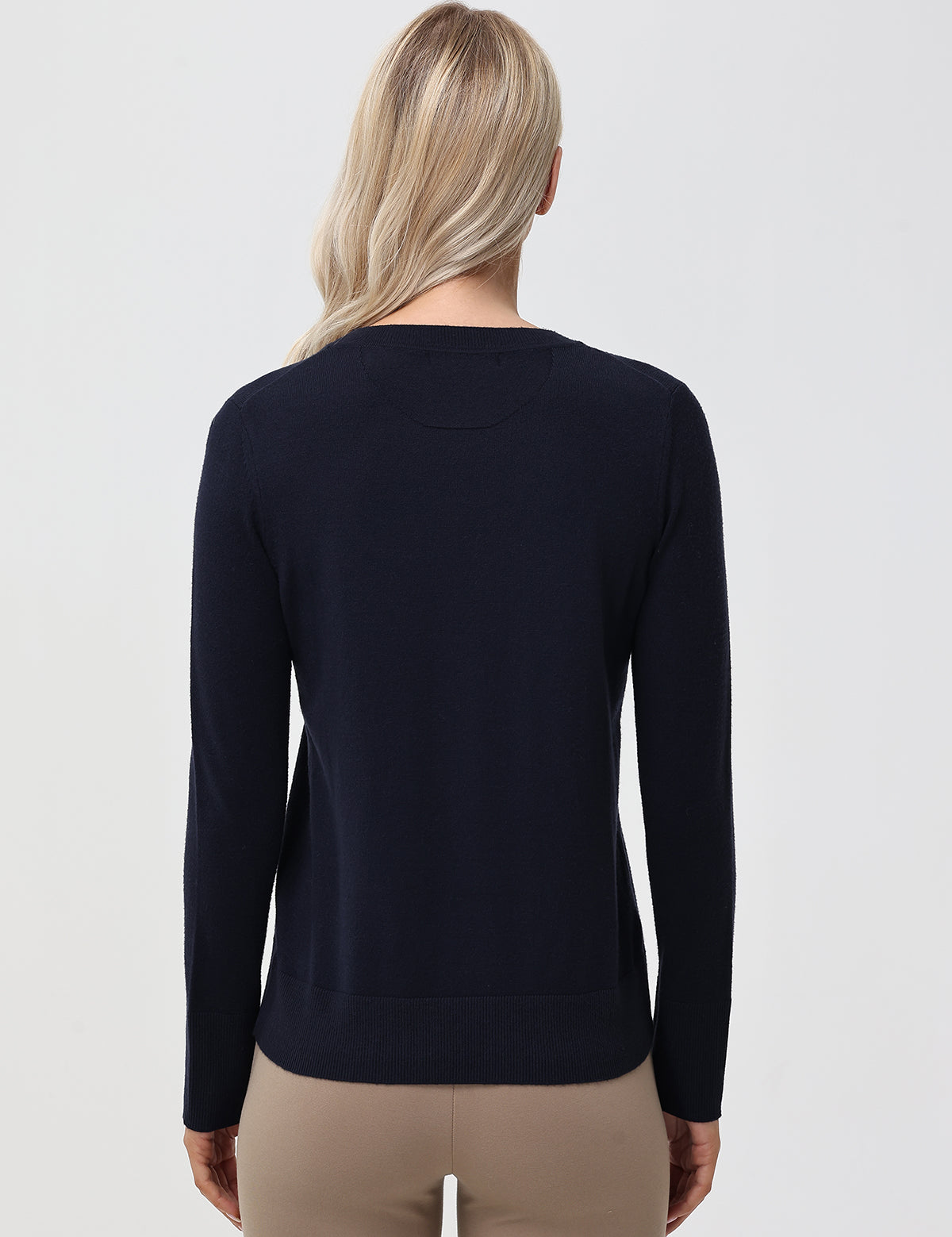 Person wearing a navy sweater on a light gray background