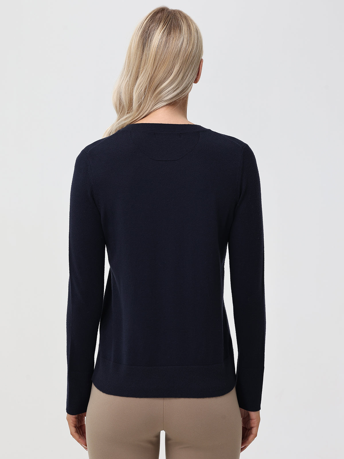 Person wearing a navy sweater on a light gray background