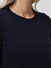 Navy blue sweater worn by a person with blonde hair, blurred background