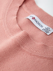 Close-up of a pink sweater with a visible label