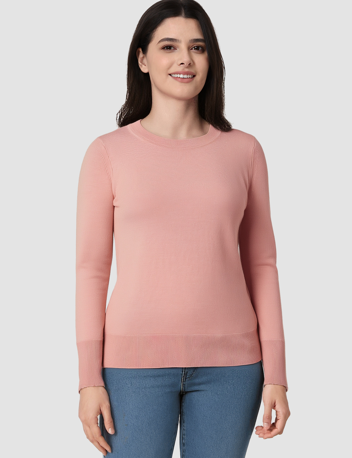 Woman wearing a pink sweater and blue jeans on a white background