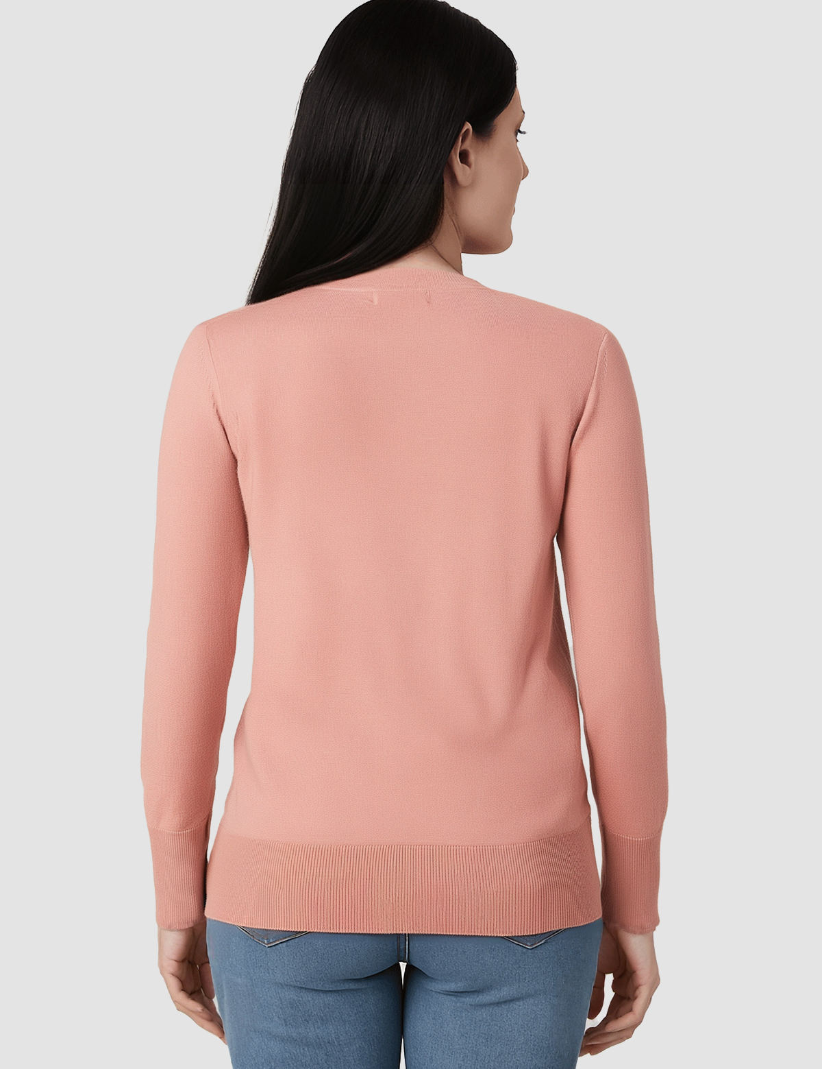 Woman wearing a pink sweater and blue jeans on a white background