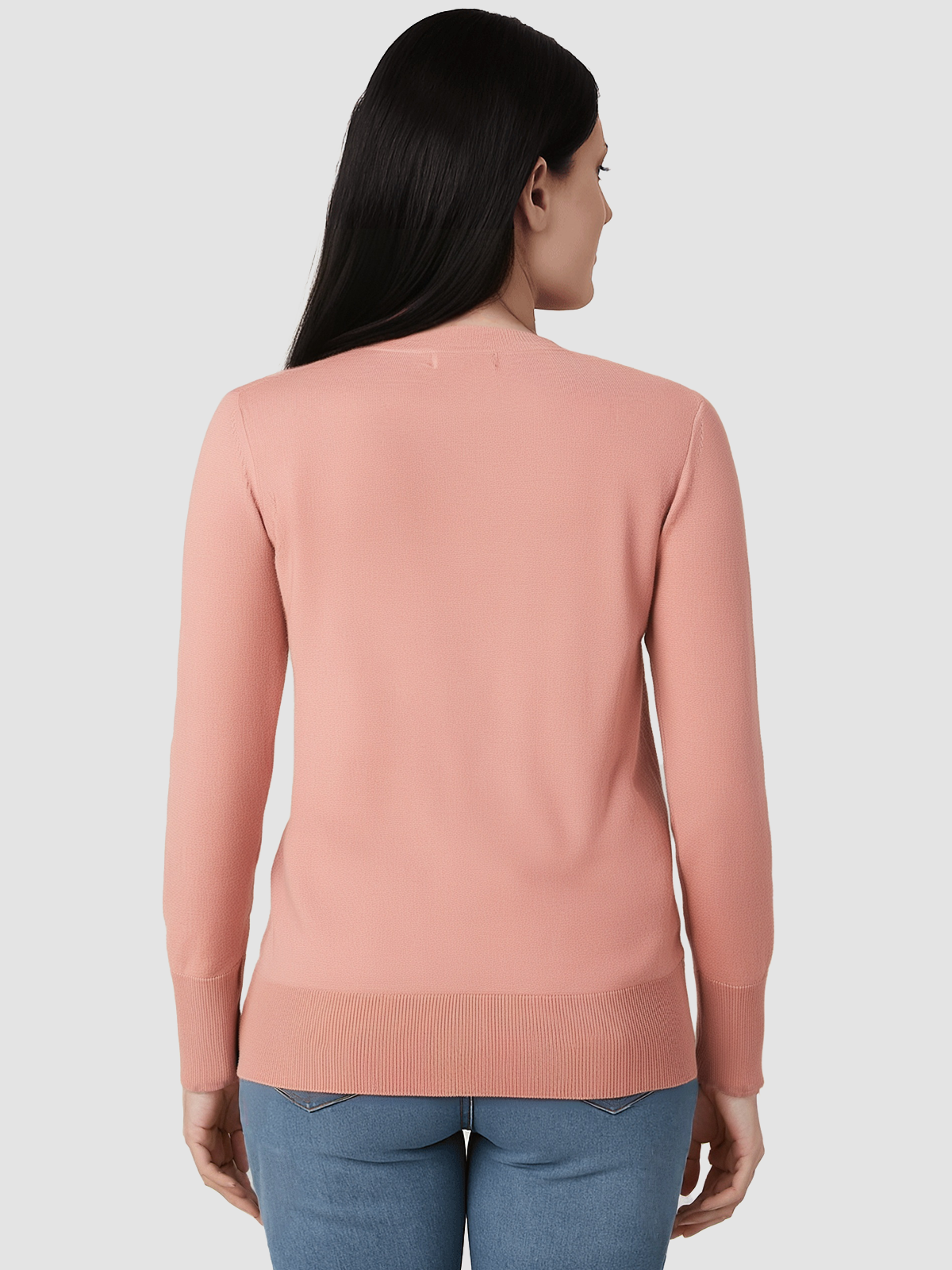 Woman wearing a pink sweater and blue jeans on a white background