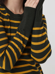 Close-up of a black and mustard yellow striped sweater on a plain background