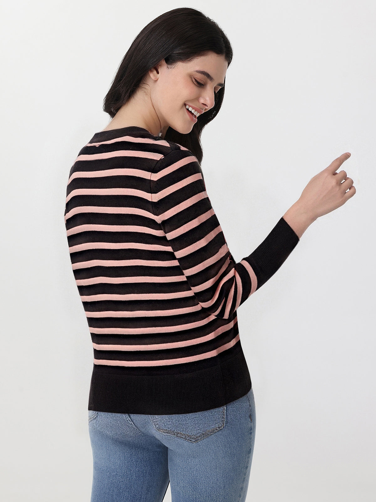 Woman wearing a black and pink striped sweater on a white background