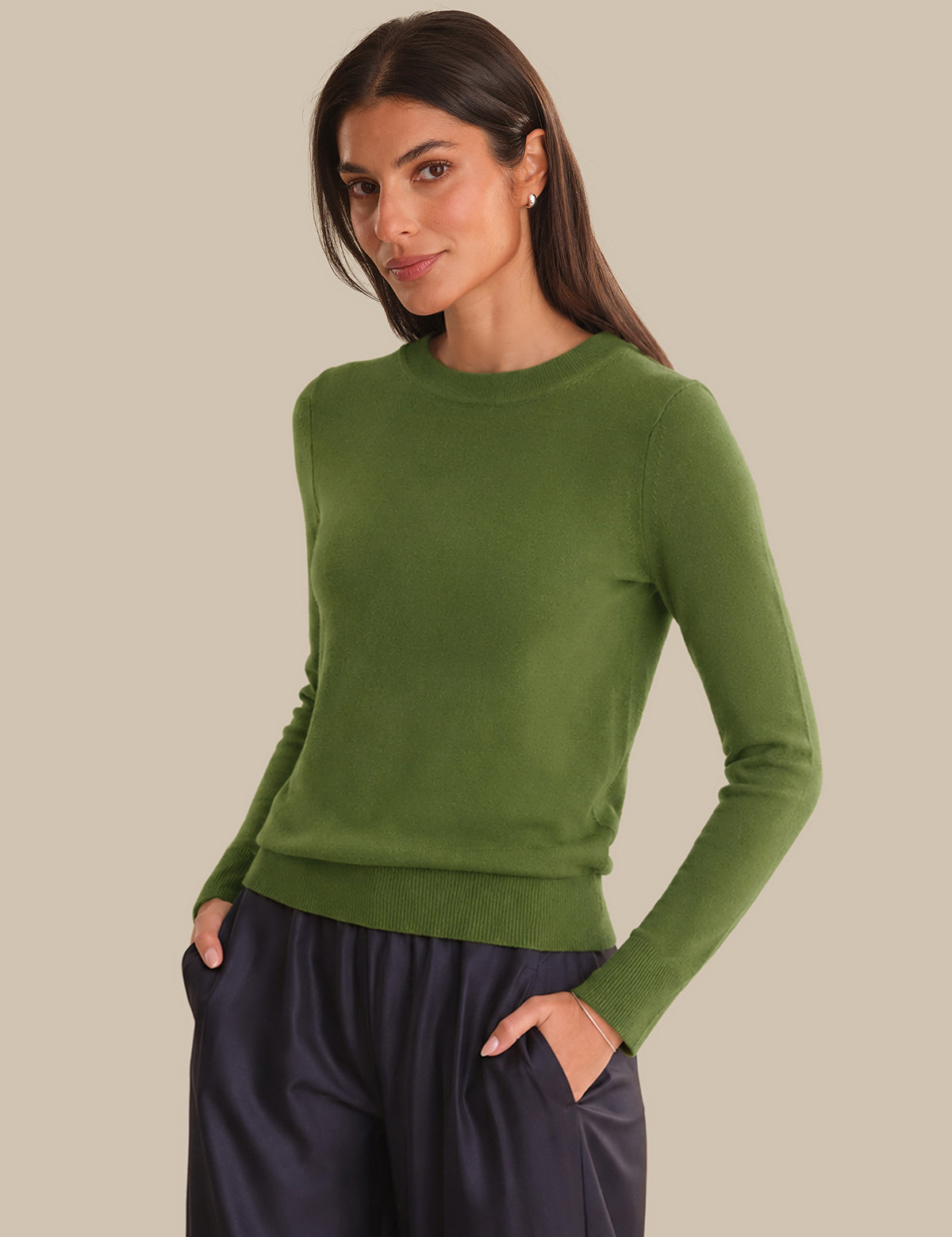 Woman wearing a green sweater against a beige background