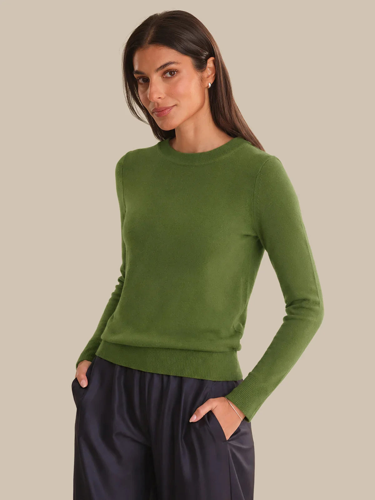 Woman wearing a green sweater against a beige background