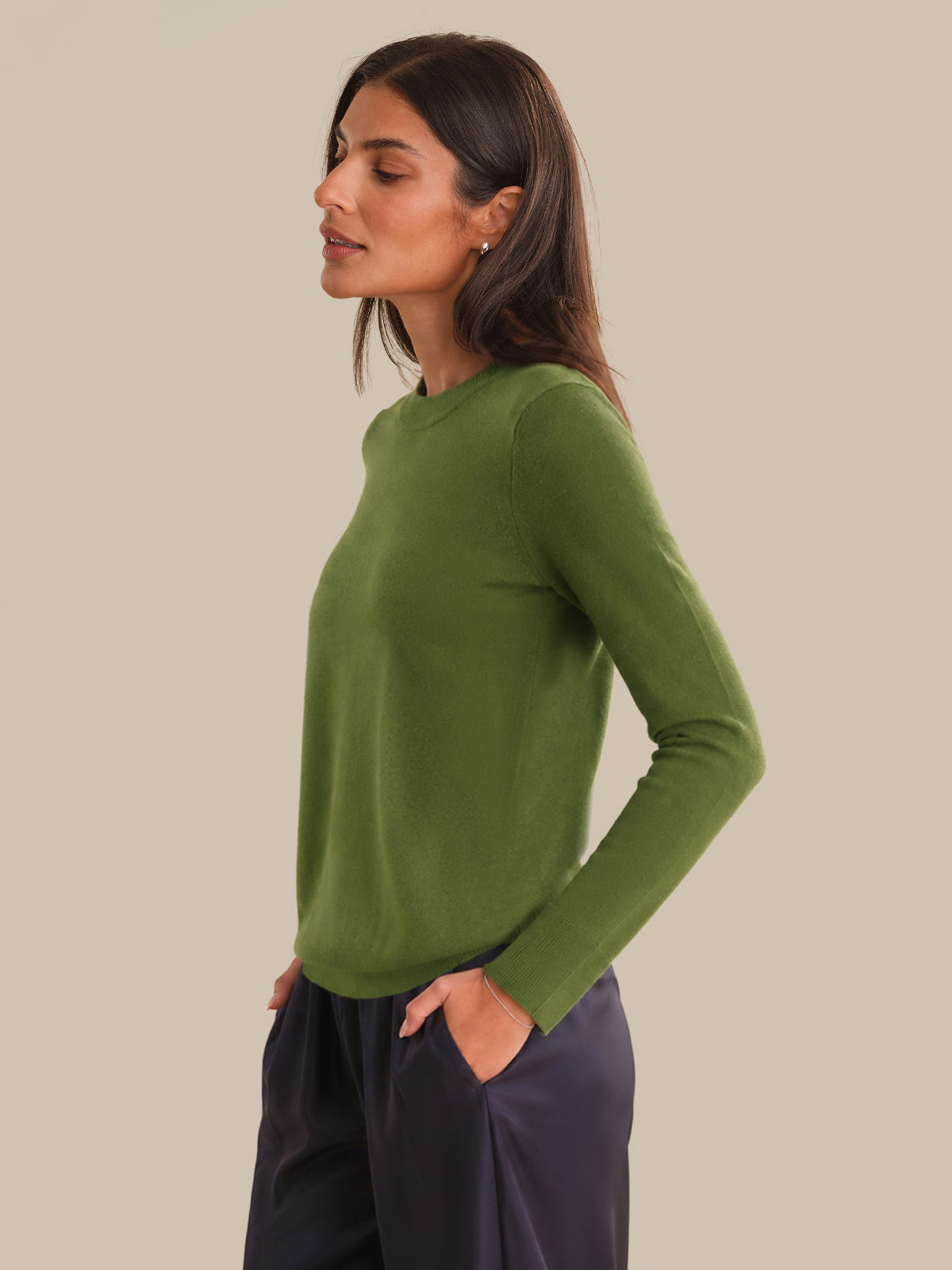 Woman wearing a green sweater against a beige background