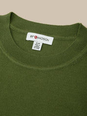 Green sweater with a brand label on the collar