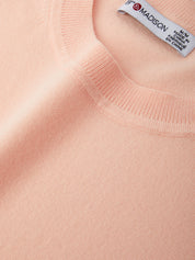 Close-up of a pink sweater with a visible label