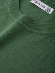 Close-up of a green sweater with a brand label on the collar.