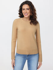 Woman wearing a beige sweater and blue jeans on a white background