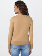 Woman wearing a beige sweater and blue jeans on a white background