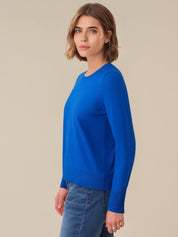 Woman wearing a blue sweater against a beige background