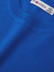 Close-up of a blue sweater with a brand label on the collar.