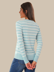Woman wearing a light blue and white striped sweater against a beige background