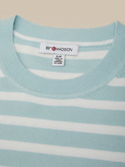 Light blue sweater with white stripes and a visible brand label on a beige background
