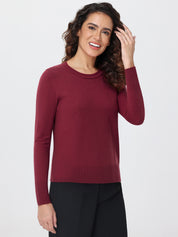 Woman wearing a burgundy long-sleeve top against a white background