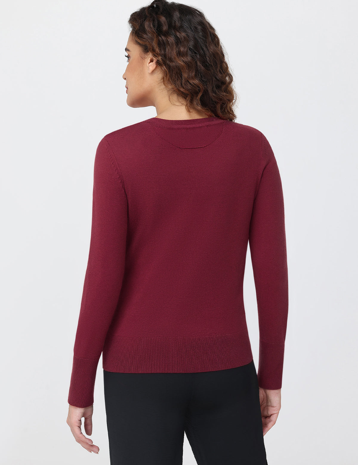 Person wearing a burgundy sweater on a white background