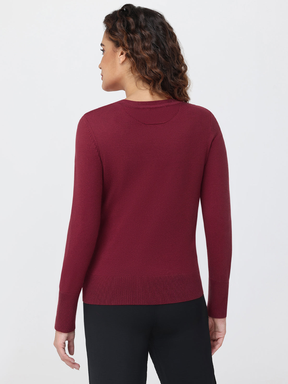 Person wearing a burgundy sweater on a white background