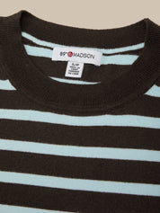 Close-up of a striped shirt with a brand label on a beige background