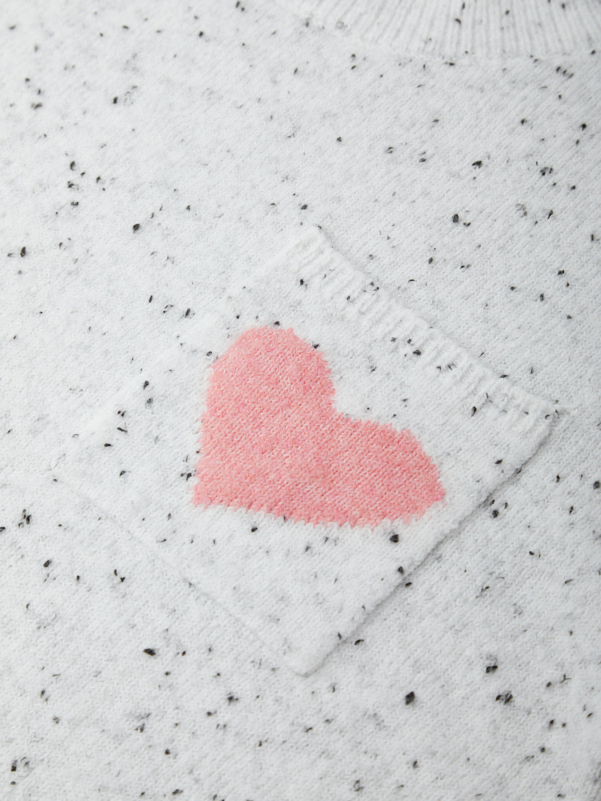 White sweater with a pink heart design