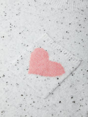 White sweater with a pink heart design