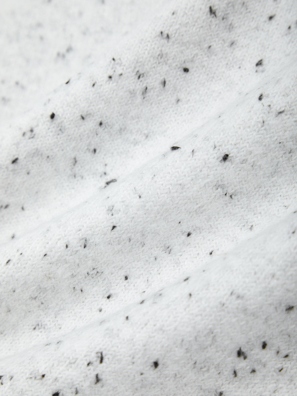 Close-up of snow with small black objects on a white background