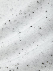 Close-up of snow with small black objects on a white background