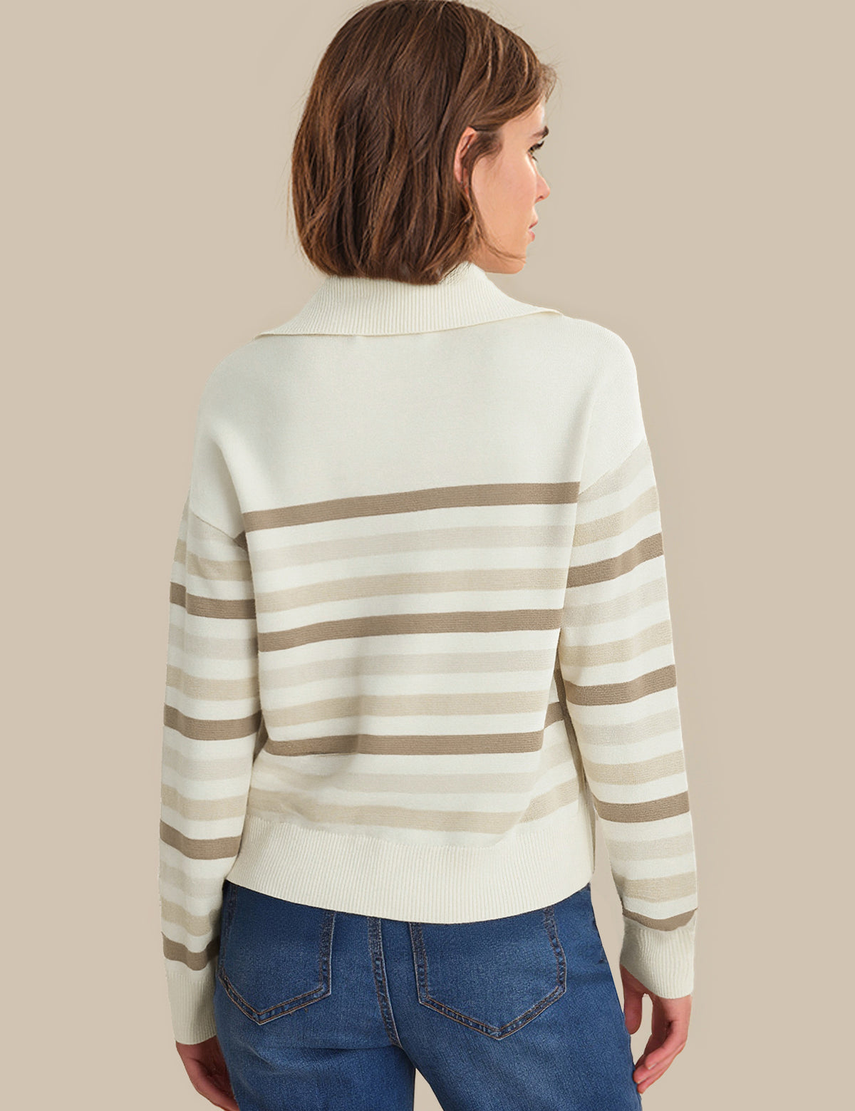 Woman wearing a striped sweater and blue jeans on a beige background