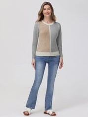 Woman wearing a gray and beige sweater with blue jeans on a white background